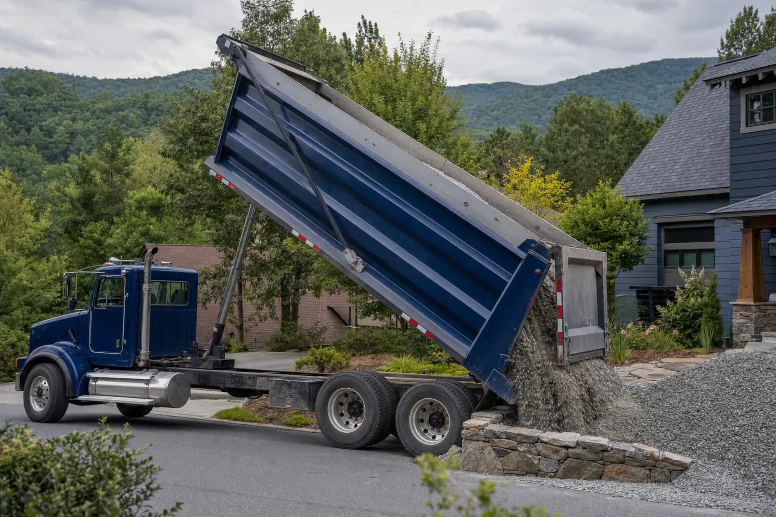 Dump truck delivering gravel to a residential property